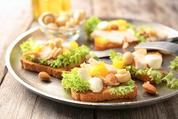 Plate with tasty chicken bruschettas, closeup