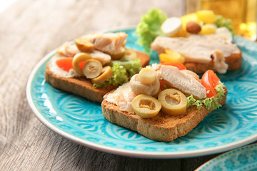 Plate with tasty chicken bruschettas, closeup