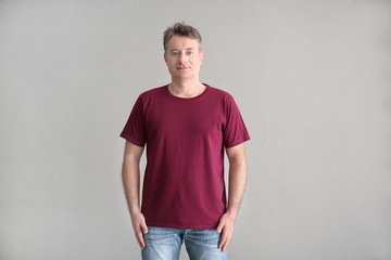Man in color t-shirt on light background. Mockup for design