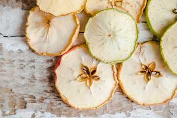 scattered slices of dried apples lie on the wooden  toned background decoration design
