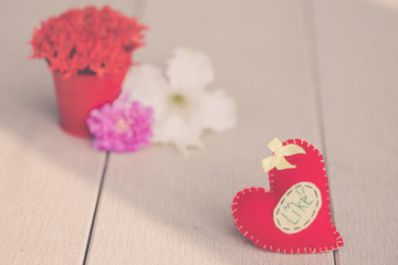A red heart with wooden hearts shape and Pink flower on wooden table background , Love, Wedding and Valentine's day concept.