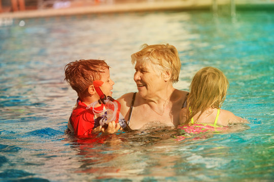 grandmother with kids swim have fun in pool