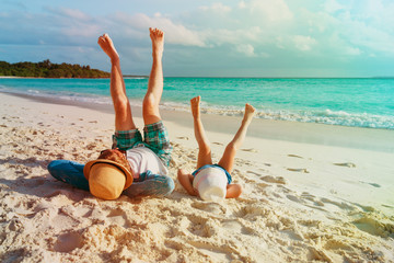 father and little daughter relax play on beach