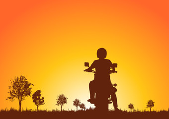 Silhouette of motorcyclists on nature at sunset.