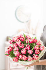 beautiful luxury bouquet of pink tulips flowers in woman hand. the work of the florist at a flower shop.