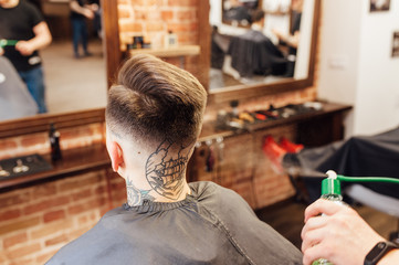 man getting trendy haircut at barber shop.