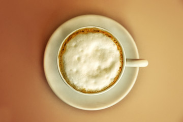 View from above on cup of capuccino. Coffe on the table. Top view of a cup of coffee