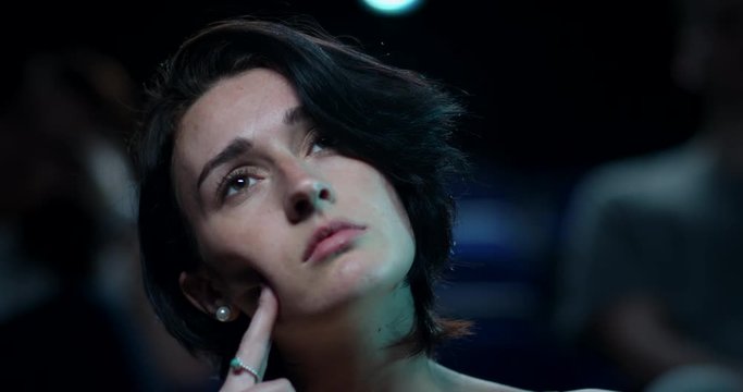 Woman in a movie theatre struggles to stay awake watching a boring movie