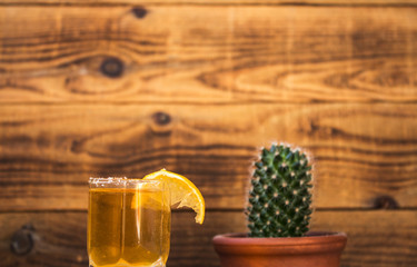 tequila with lemon and cactus on a wooden bacground