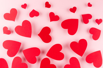 Paper red hearts fly on soft pink color background. Valentine day concept for design.