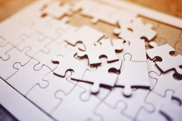 A white jigsaw puzzle is placed on it.
