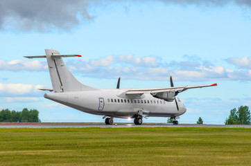 Fototapeta na wymiar Passenger turboprop airplane landing the runway against the blue sky.
