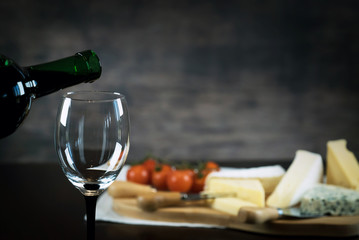 pouring red wine and cheese variety