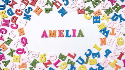 Baby name AMELIA composed of wooden letters on floor. Choosing name concept
