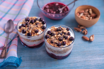 Delicious dessert - yogurt parfait with jam, nuts and currants in a glass