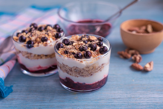 Delicious dessert - yogurt parfait with jam, nuts and currants in a glass