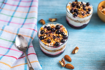 yogurt parfait with granola and currant in a glass on a rustic  background