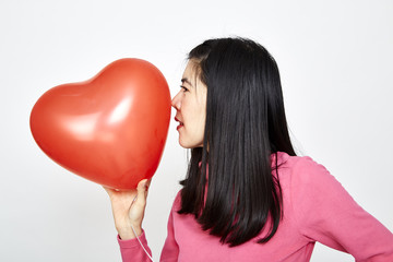 Fototapeta na wymiar Woman holding red heart shaped balloon