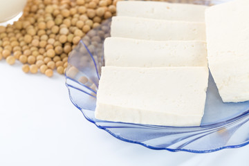 Tofu, soy milk, and soybeans on white background