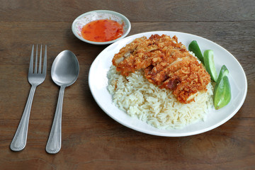 Fry chicken and rice in white dish with sweet sauce on wood table background.
