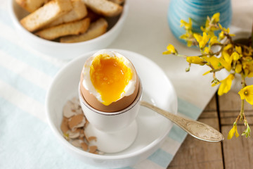 Breakfast from soft-boiled egg, bread toast, coffee with cream and fresh newspaper.
