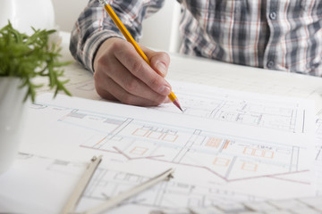 Architects working on blueprint, real estate project. Architect workplace - architectural project, blueprints, ruler, calculator, laptop and divider compass. Construction concept. Engineering tools.