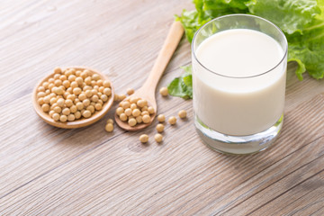 Glass of Soy Milk and Seeds on wooden table.