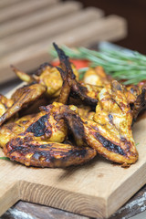 Grilled chicken wings on a light oak surface.