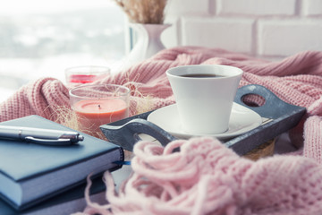 cup of coffee on a table in front of a window, the concept of breakfast and rest during work, a lifestyle of authentic, selective focus