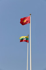 National flag of Vietnam and Myanmar on bright blue sky background. Blown away by wind. Its are two of the ten Association of South East Asian Nations. The concept of bilateral or relationship.