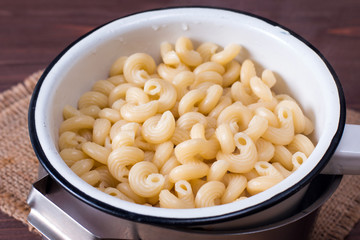 Fresh cooked Pasta in a sieve on a wooden table