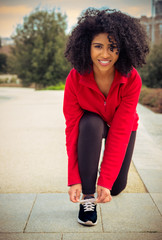 Beautiful athlete woman tying shoes to run in the park