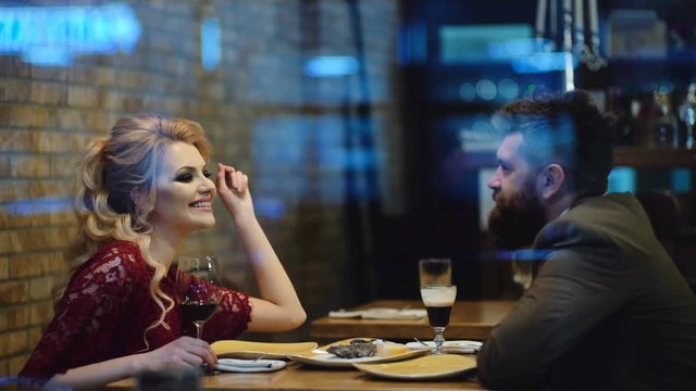Beautiful couple in a restaurant. Romantic couple dating in pub at night. Couple have romantic evening in restaurant.