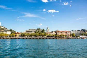 Beautiful small European town by the lake. Medieval Como Cathedral on Lake Como in Lombardy, Italy. Como Cathedral and Como city embankment the view from the lake.