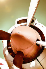 Closeup of an old airplane turboprop engine with propeller blades and parts of aircraft fuselage -...