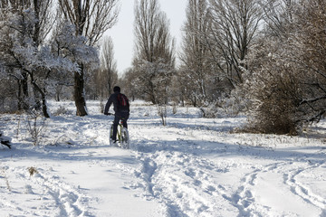 Fototapeta na wymiar the guy on a bike is riding in the snow