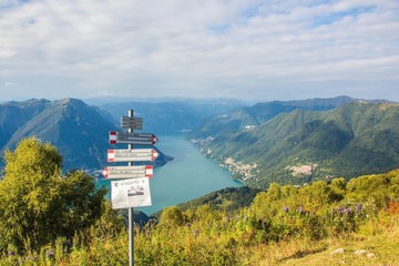 The beautiful mountain landscape. Mountains, lake, pointer, and small towns. Pointer on the Mountain Monte Boletto. Views of lake Como. Lombardy, Italy.
