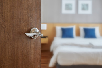 Hotel room interior, Condominium or apartment doorway with opened door in front of blur bedroom...