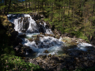 Wasserfall im Wald mit Sonne in Frankreich