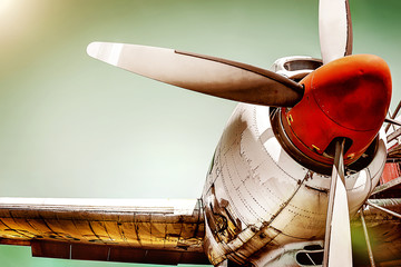 Closeup of an old airplane turboprop engine with propeller blades, parts of wings and aircraft fuselage - historic vintage plane in dramatic look retro style