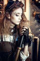 Fototapeta premium Portrait of a beautiful steampunk woman, with a telescope on a grunge gear background.