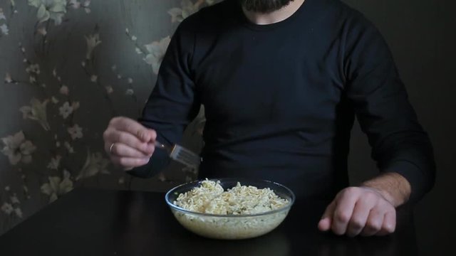 bearded man eating instant noodles