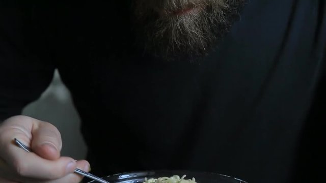 bearded man eating instant noodles