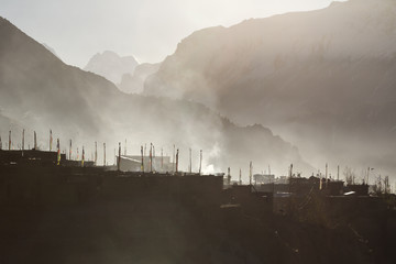 Prayer flags in mountain village Manang. Foggy morning, Nepal, Himalayas, Annapurna Conservation Area