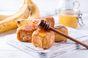 Cottage cheese pancakes in the form of cubes with honey on a white background