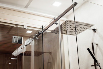 Metal structure of the upper fasteners and rollers for the sliding glass door in the shower...
