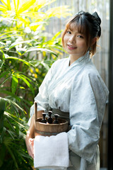 Onsen series: Asian woman holding wooden bucket in onsen