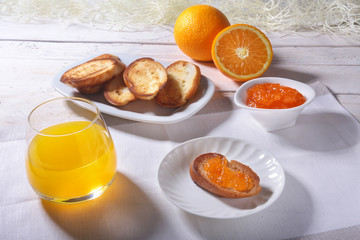 Fototapeta na wymiar Morning Breakfast set with orange jam on bread toast and juice in glass.