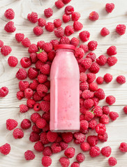 Raspberry around bottle of yogurt on wooden table. Fresh yogurt. Healthy food concept. High resolution product. Top view © Romario Ien