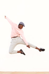 young african man jumping in air on sidewalk outdoors